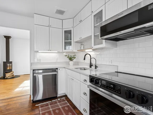 a kitchen with stainless steel appliances a stove a sink and cabinets