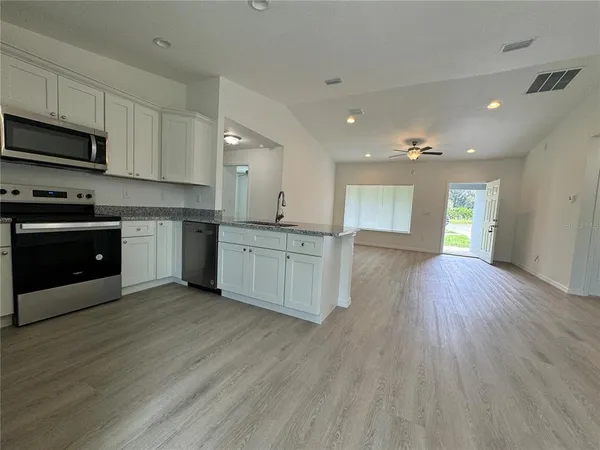 a large kitchen with stainless steel appliances granite countertop a large counter top and a stove top oven