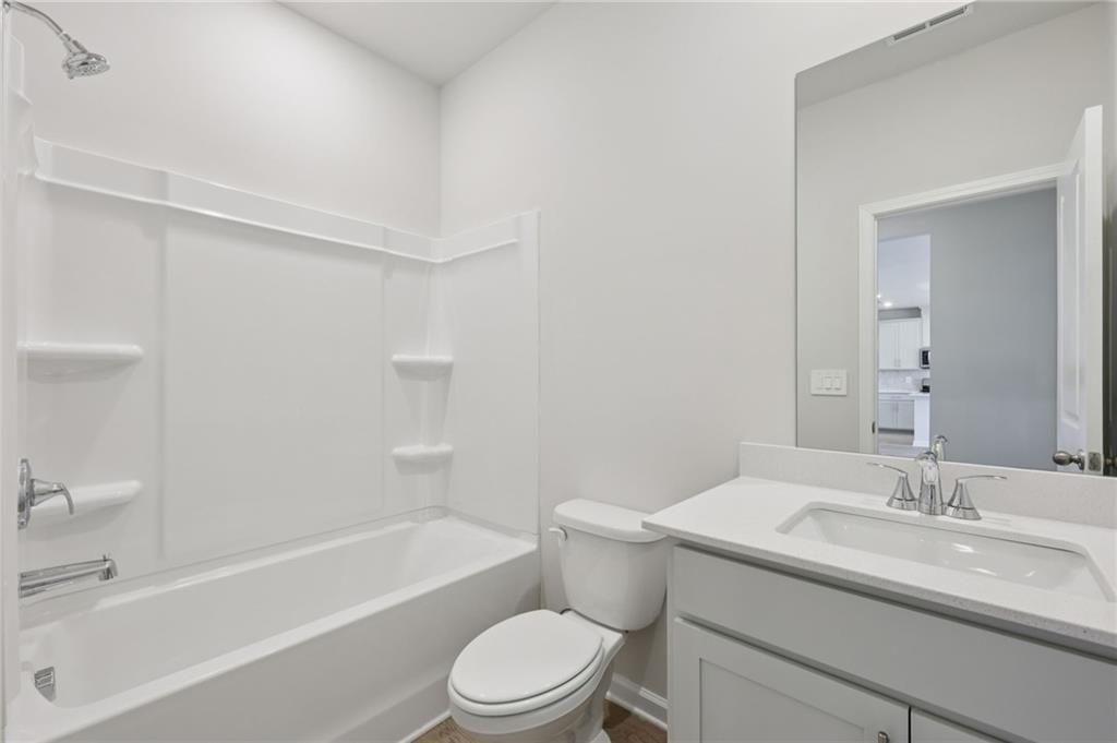 1489 High Fls Lane Grayson, GA 30017 - Photo 19 of 44 a bathroom with a granite countertop sink toilet and bathtub