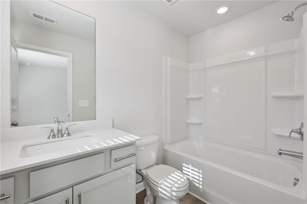 1489 High Fls Lane Grayson, GA 30017 - Photo 34 of 44 a bathroom with a bathtub shower sink vanity and toilet