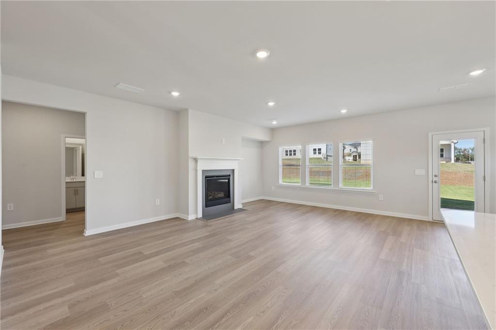 1489 High Fls Lane Grayson, GA 30017 - Photo 5 of 44 a view of an empty room with wooden floor and a fireplace