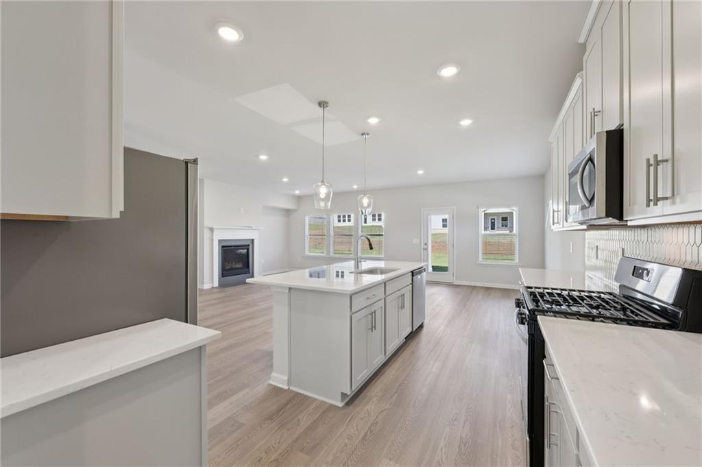 1489 High Fls Lane Grayson, GA 30017 - Photo 8 of 44 a large kitchen with a large counter top a sink stainless steel appliances and cabinets
