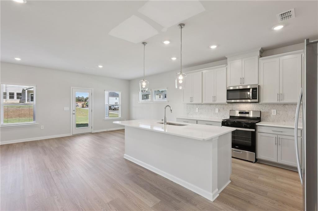 1489 High Fls Lane Grayson, GA 30017 - Photo 9 of 44 a kitchen with stainless steel appliances granite countertop a sink stove and oven