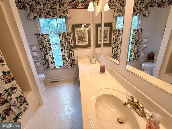 a bathroom with a sink mirror vanity and bathtub