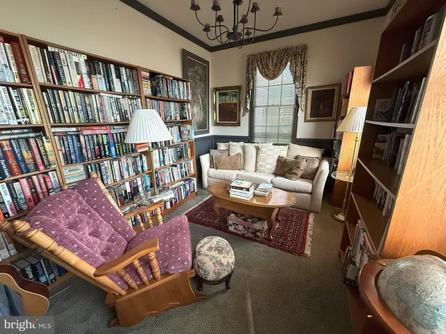 a living room with furniture and a book shelf
