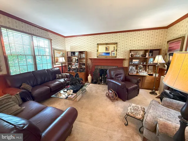 a living room with furniture fireplace and a large window