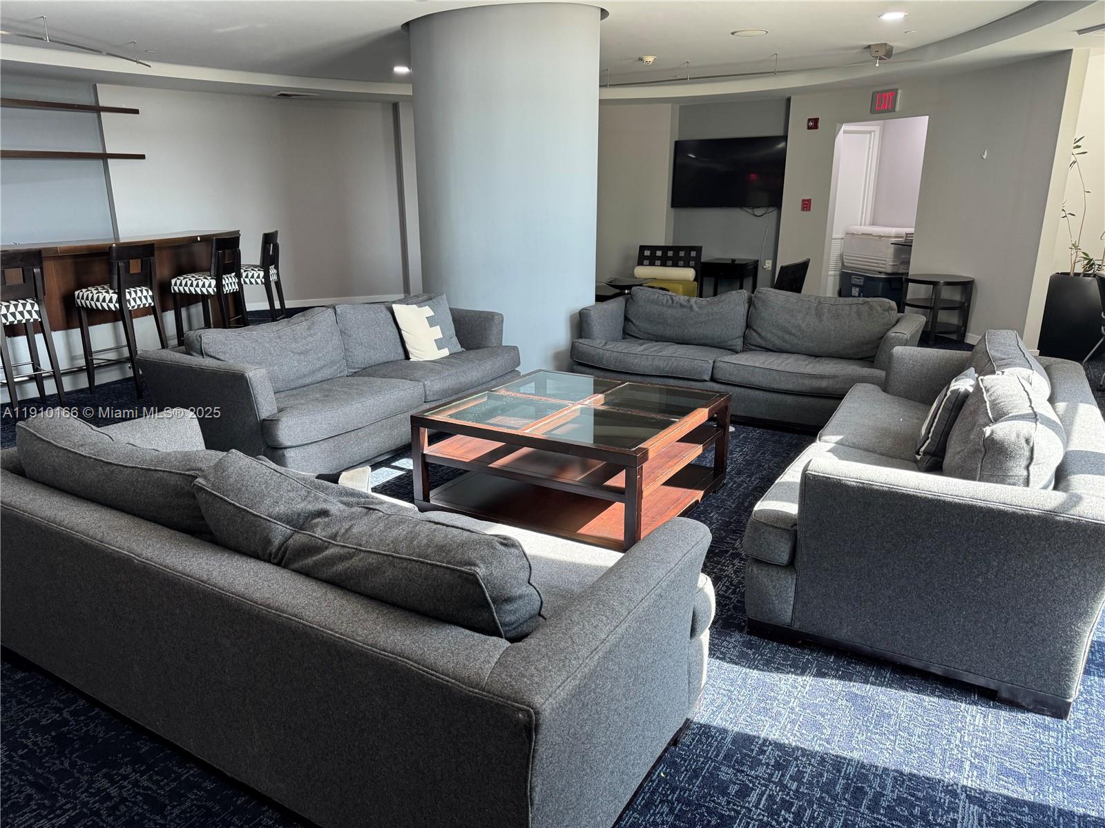 9055 Southwest 73rd Court, Unit 406 Miami, FL 33156 - Photo 14 of 18 a living room with furniture and a lamp