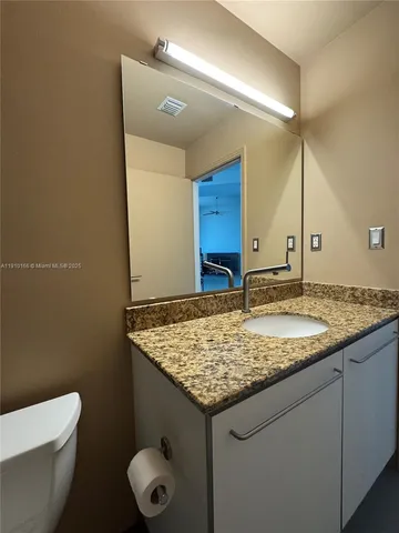 a bathroom with a granite countertop sink and a mirror