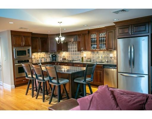 111 Sutton Road Needham, MA 02492 - Photo 12 of 30 a kitchen with stainless steel appliances kitchen island granite countertop a refrigerator a stove a sink with dining table and chairs