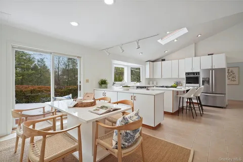 a kitchen with a table chairs microwave and cabinets