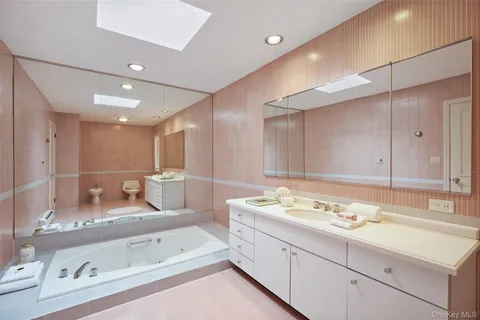 a bathroom with a tub sink and mirror