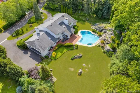 an aerial view of a house with a swimming pool and garden