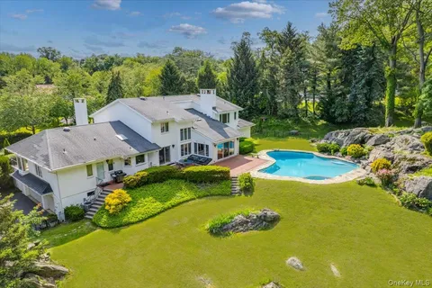 an aerial view of a house with swimming pool and garden