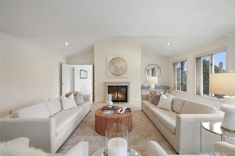 a living room with furniture a fireplace and a large window