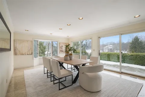 a dining room with furniture and large windows