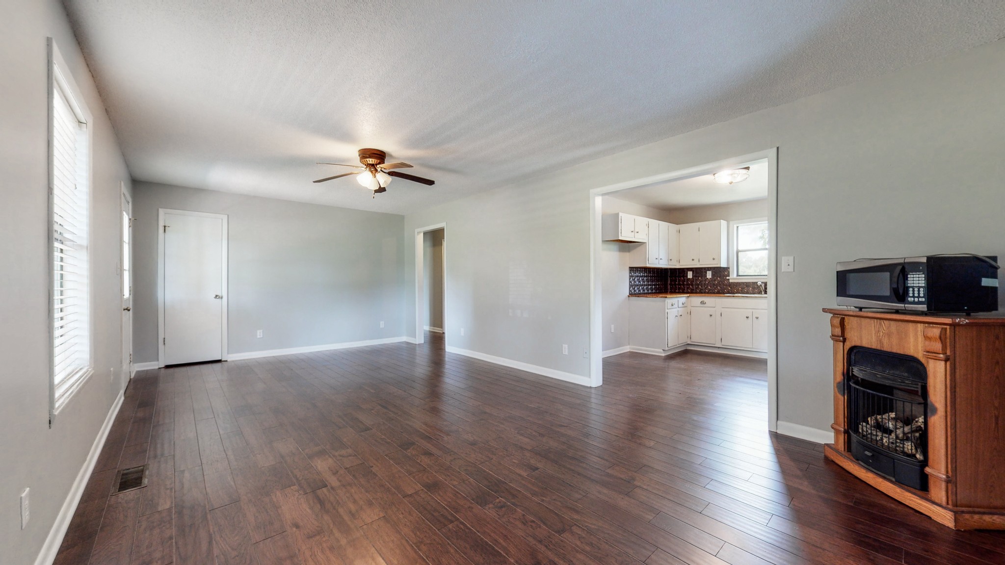 83 Hotel Road Flintville, TN 37335 - Photo 6 of 39 a view of a livingroom with a fireplace a ceiling fan and wooden floor