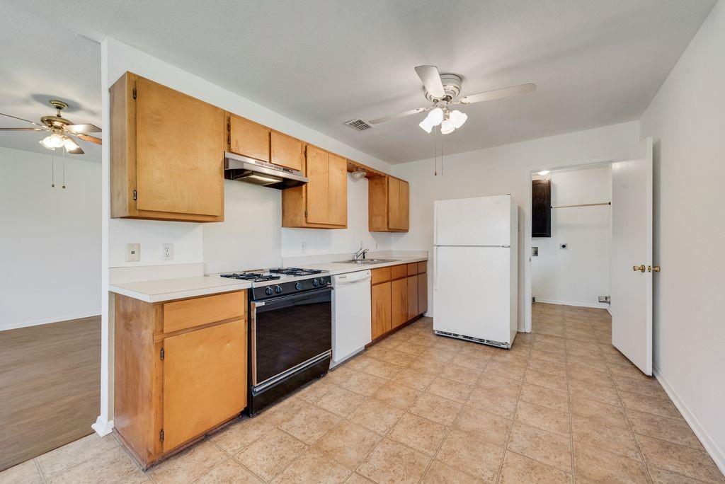 301 Lipscomb Street Cleburne, TX 76031 - Photo 6 of 21 a kitchen with stainless steel appliances granite countertop a stove and a refrigerator