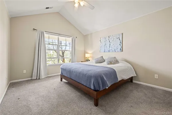a spacious bedroom with a bed and a large window