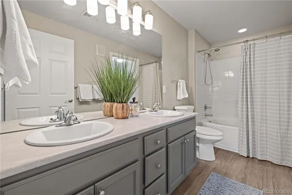 a bathroom with a double vanity sink toilet and a mirror