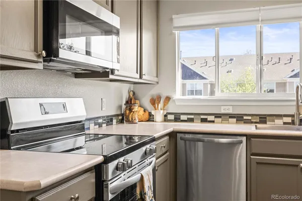 a kitchen with stainless steel appliances a sink a stove and a window