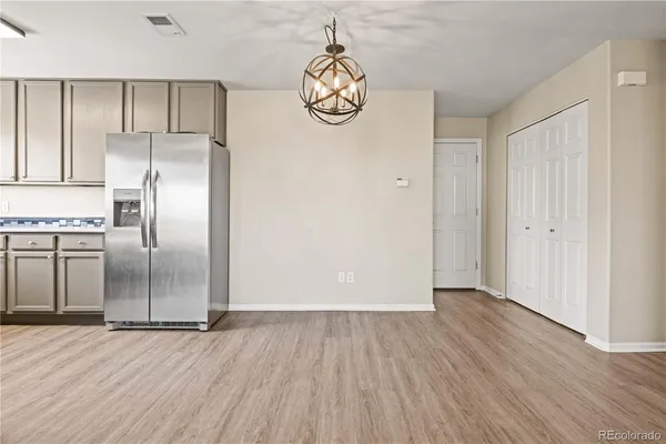 a view of a kitchen with wooden floor and electronic appliances