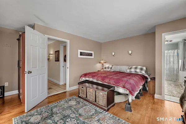 a bedroom with a bed and wooden floor