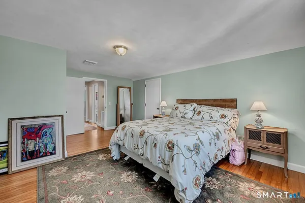 a bedroom with a bed and a painting on the wall