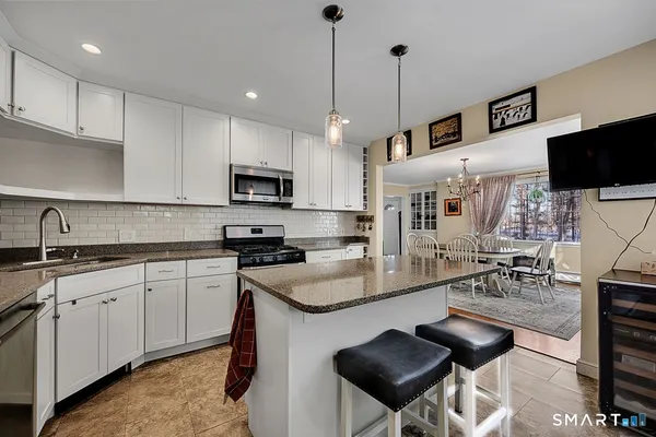 a kitchen with granite countertop a sink counter top space appliances and cabinets