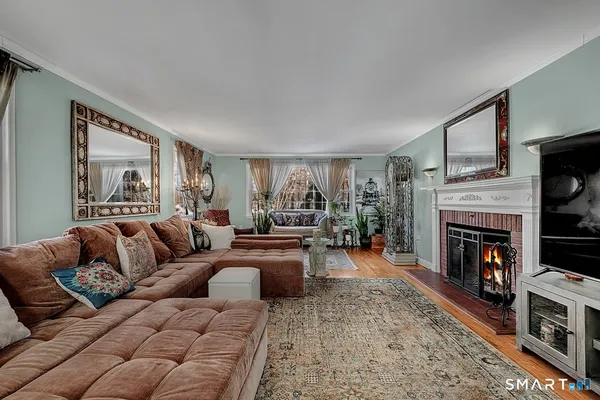 a living room with furniture large window and a fireplace
