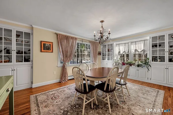 a dining room with wooden floor and chandelier