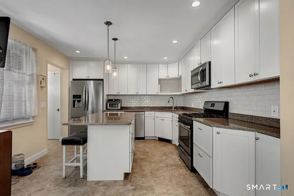 a kitchen with stainless steel appliances granite countertop a refrigerator sink and cabinets