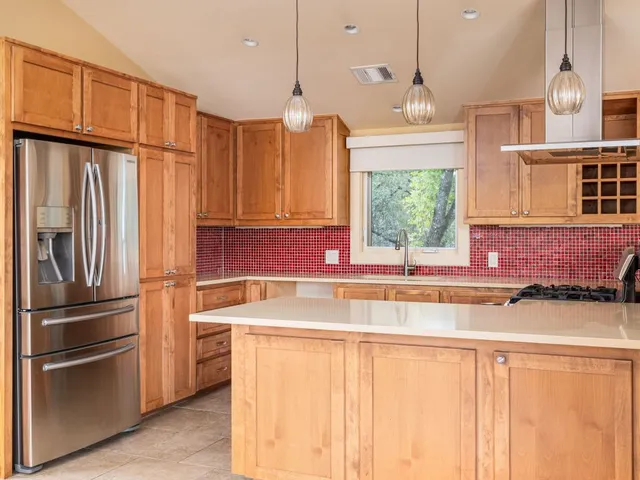 a kitchen with stainless steel appliances granite countertop a refrigerator and a sink