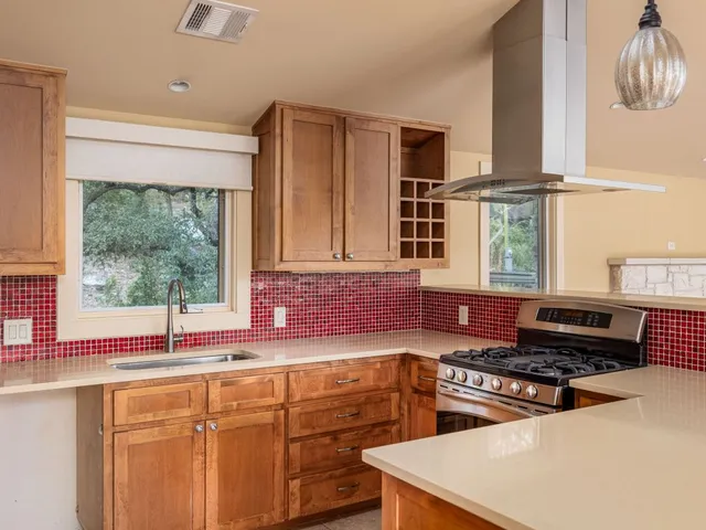 a kitchen with stainless steel appliances a sink a stove and a window