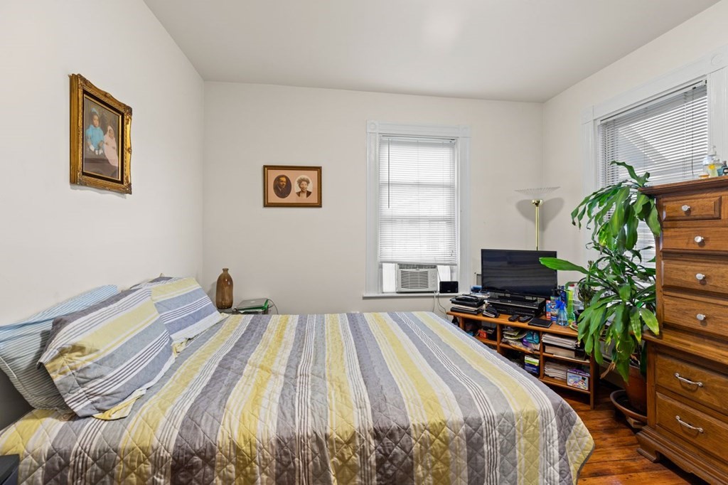 1 Copeland Place Boston, MA 02119 - Photo 18 of 31 a bedroom with a bed and a flat screen tv