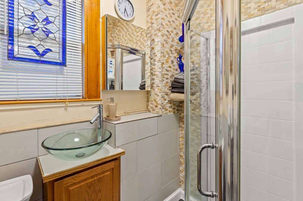 1 Copeland Place Boston, MA 02119 - Photo 22 of 31 a bathroom with a sink a toilet and shower curtain