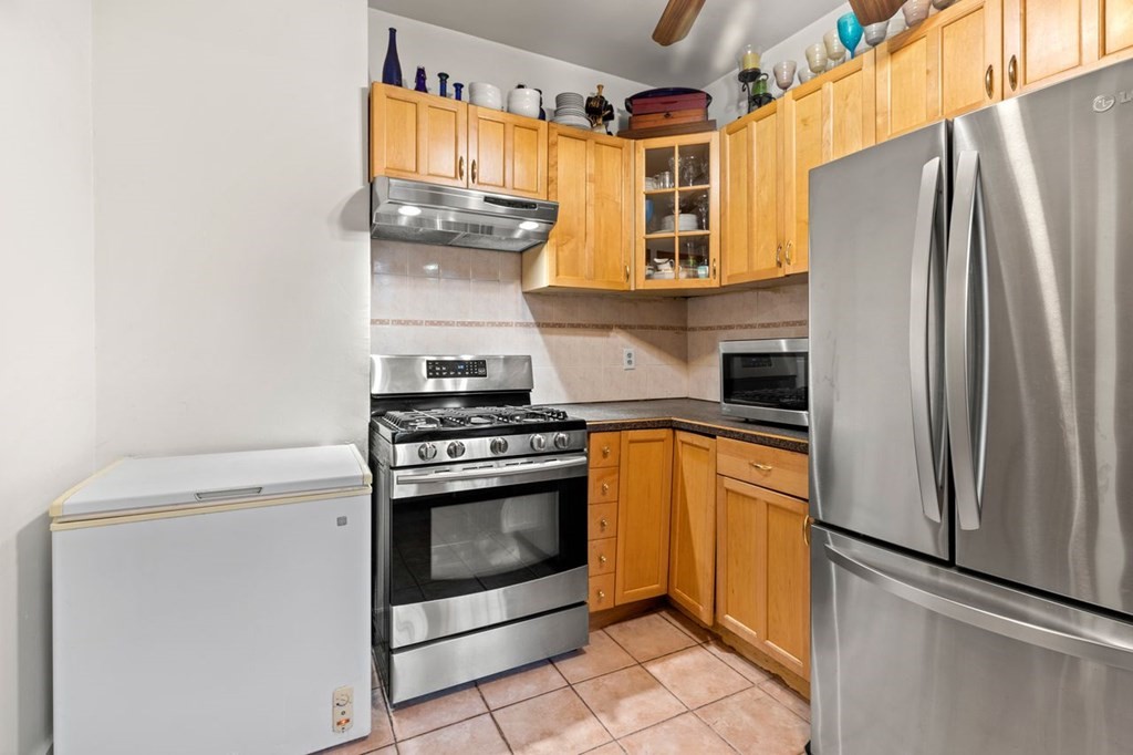 1 Copeland Place Boston, MA 02119 - Photo 23 of 31 a kitchen with stainless steel appliances granite countertop a refrigerator and a stove