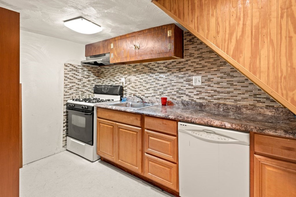 1 Copeland Place Boston, MA 02119 - Photo 24 of 31 a kitchen with stainless steel appliances granite countertop a sink and a stove