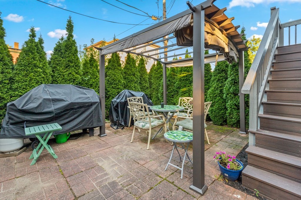 1 Copeland Place Boston, MA 02119 - Photo 28 of 31 a view of a patio with table and chairs potted plants with wooden floor and fence