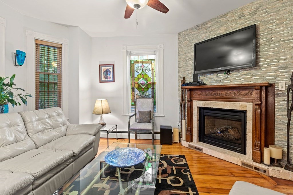 1 Copeland Place Boston, MA 02119 - Photo 7 of 31 a living room with furniture a flat screen tv and a fireplace