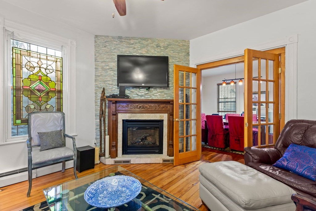 1 Copeland Place Boston, MA 02119 - Photo 9 of 31 a living room with furniture a flat screen tv and a fireplace
