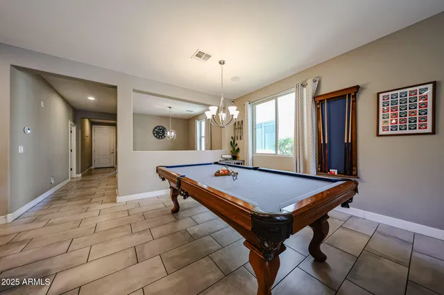 a room with pool table and windows