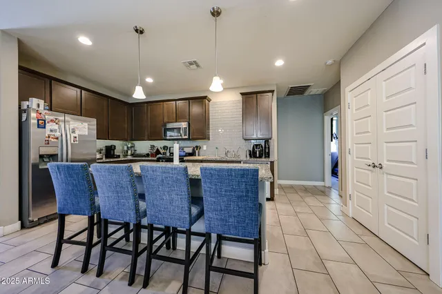 a kitchen with stainless steel appliances granite countertop a refrigerator and a stove top oven