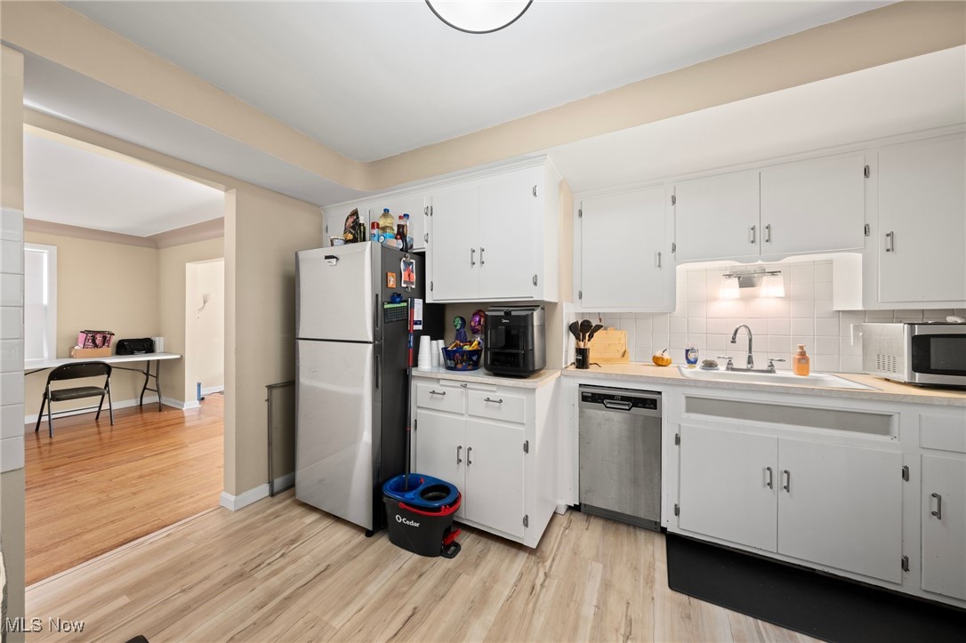13517 Cedar Road Cleveland, OH 44118 - Photo 23 of 30 Kitchen with light hardwood / wood-style flooring, tasteful backsplash, white cabinetry, and stainless steel appliances