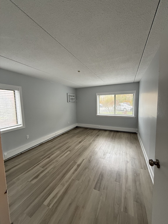 575 Broad Street, Unit 101 Weymouth, MA 02189 - Photo 6 of 9 an empty room with wooden floor and windows