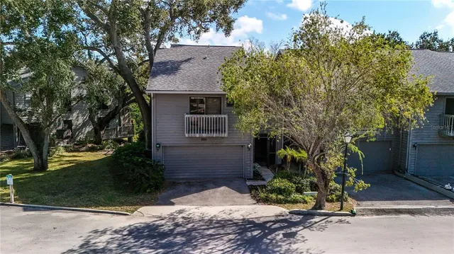 a view of a house with a yard and large tree