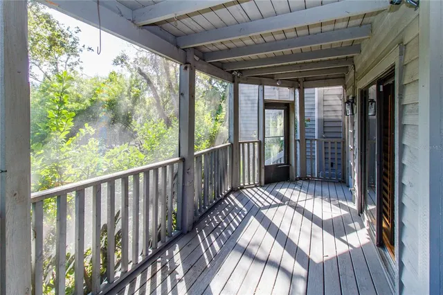 a view of backyard with large trees and wooden fence