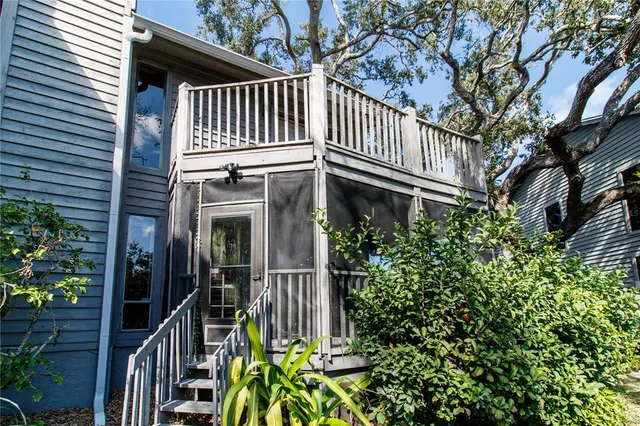 a view of a house with a small deck and furniture