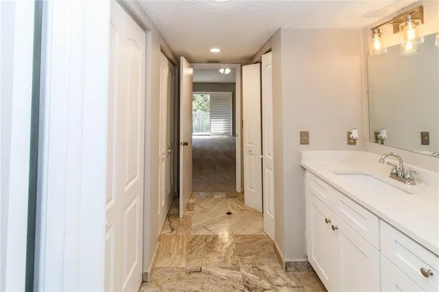 an empty room with a chandelier fan and closet
