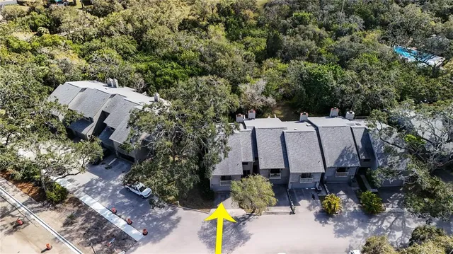 an aerial view of a house with a yard and trees