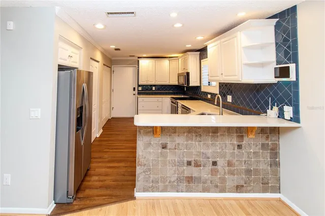 a kitchen with stainless steel appliances a refrigerator and a counter top space